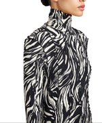 A woman wearing the Mabel Marble Jersey Dress by Proenza Schouler White Label, featuring long sleeves and a black and white abstract zebra print.