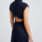 A person wears the Proenza Schouler White Label Brea Brushed Rib Dress in navy, featuring a high collar, short sleeves, open back, and A-line silhouette. The figure is seen from behind against a plain light background.
