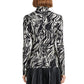 A person shown from the back wears the Audrey Marble Jersey Top by Proenza Schouler White Label—a slim, long-sleeve turtleneck with a black and white print—paired with a black pleated skirt.