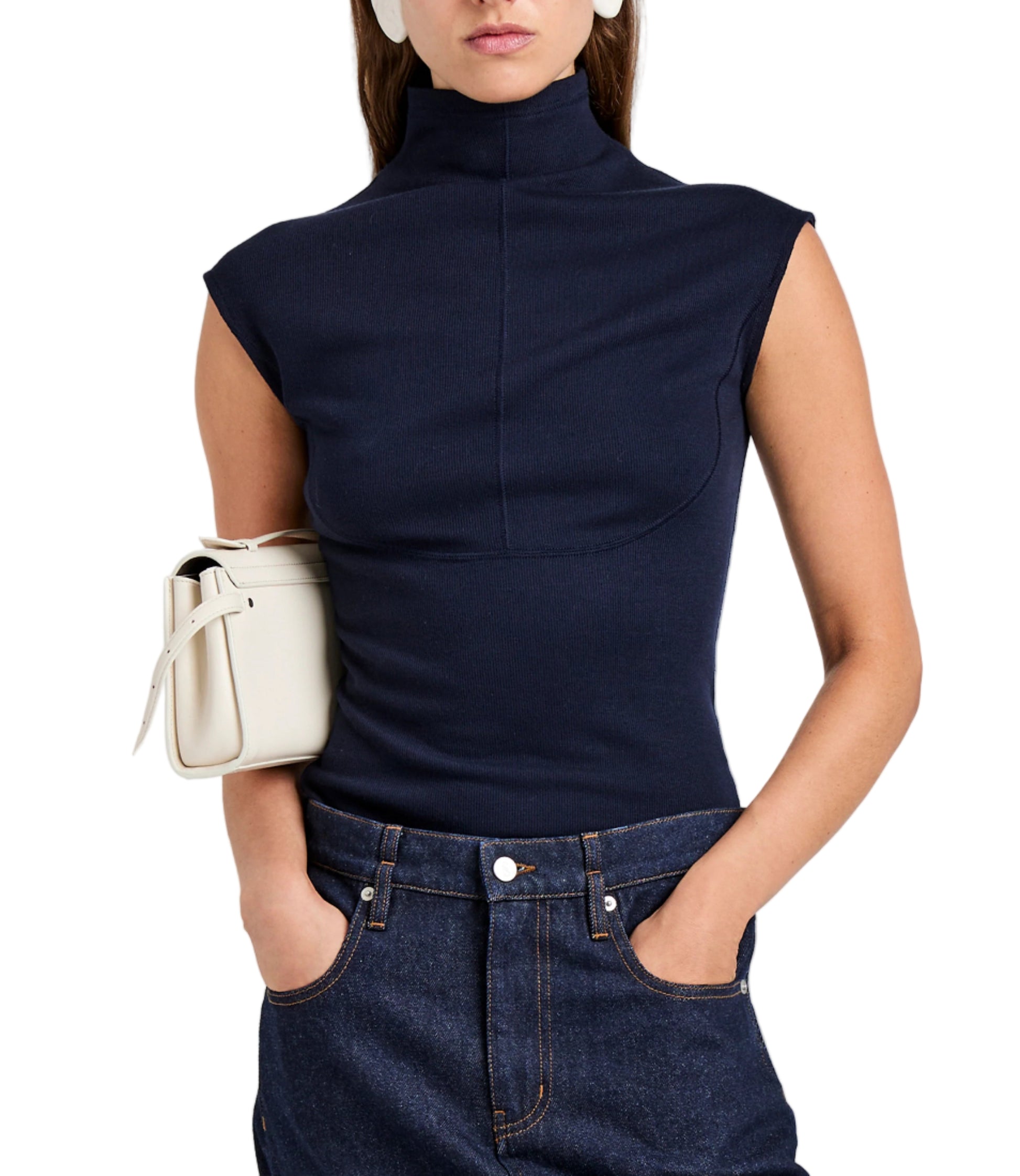 A woman wears the Proenza Schouler White Label Zane Brushed Rib Top in navy with dark jeans, hands in pockets, and a white handbag under her arm.