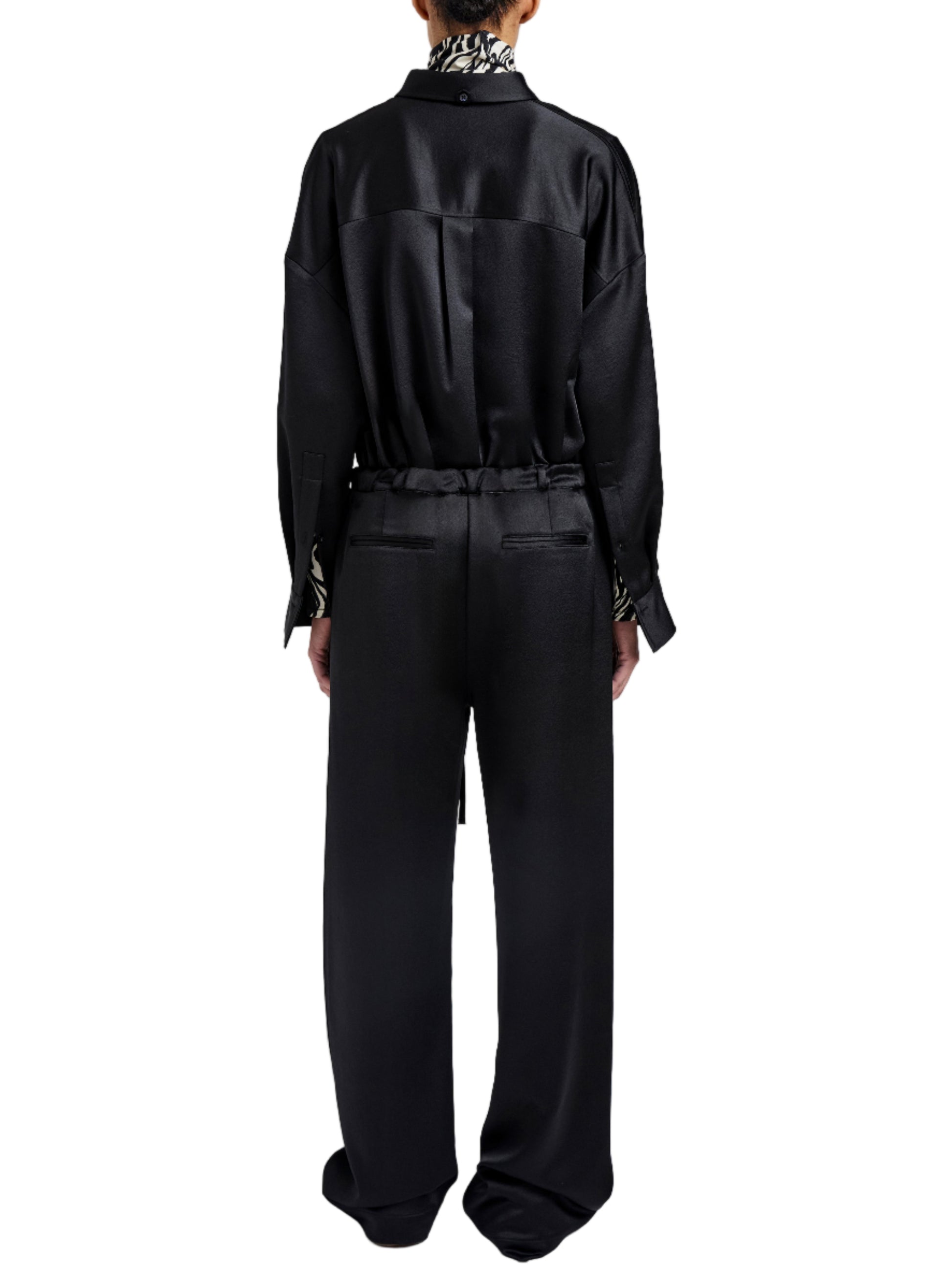 Person stands with their back to the camera, wearing a loose black long-sleeve shirt paired with Proenza Schouler White Label's Magnus Crinkled Crepe Pant—a high-waisted, wide-leg style.