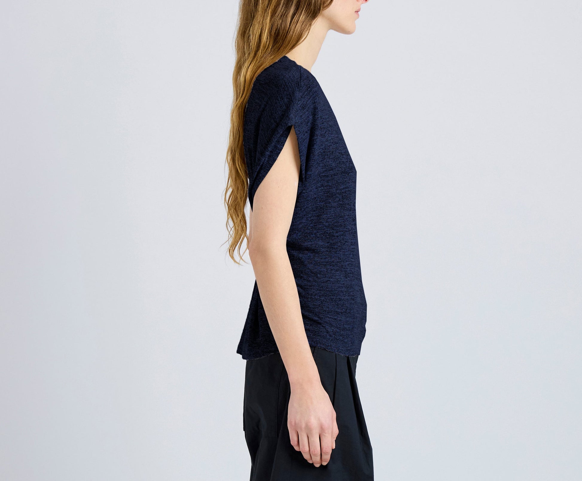 A person with long hair wears the Reeva Marled Jersey Top by Proenza Schouler White Label and black pants, shown in side profile against a plain light background.