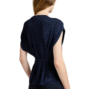 A person with light skin and brown hair is seen from the back wearing the Proenza Schouler White Label Reeva Marled Jersey Top, a navy blue sleeveless cropped tee with a cinched waist detail.
