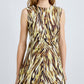 A woman wears the Anoushka Dress by Proenza Schouler White Label, a sleeveless poplin dress with yellow, brown, and black abstract brushstroke print, standing against a plain light background.