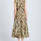 A woman stands facing away, wearing the Proenza Schouler White Label Anoushka Dress—a sleeveless, ankle-length poplin dress with a yellow, brown, and black abstract brushstroke print—paired with black sandals.