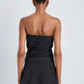 Person shown from the back wearing the Maisy Strapless Top by Proenza Schouler White Label and black pants, with short hair and gold hoop earrings, set against a plain background.