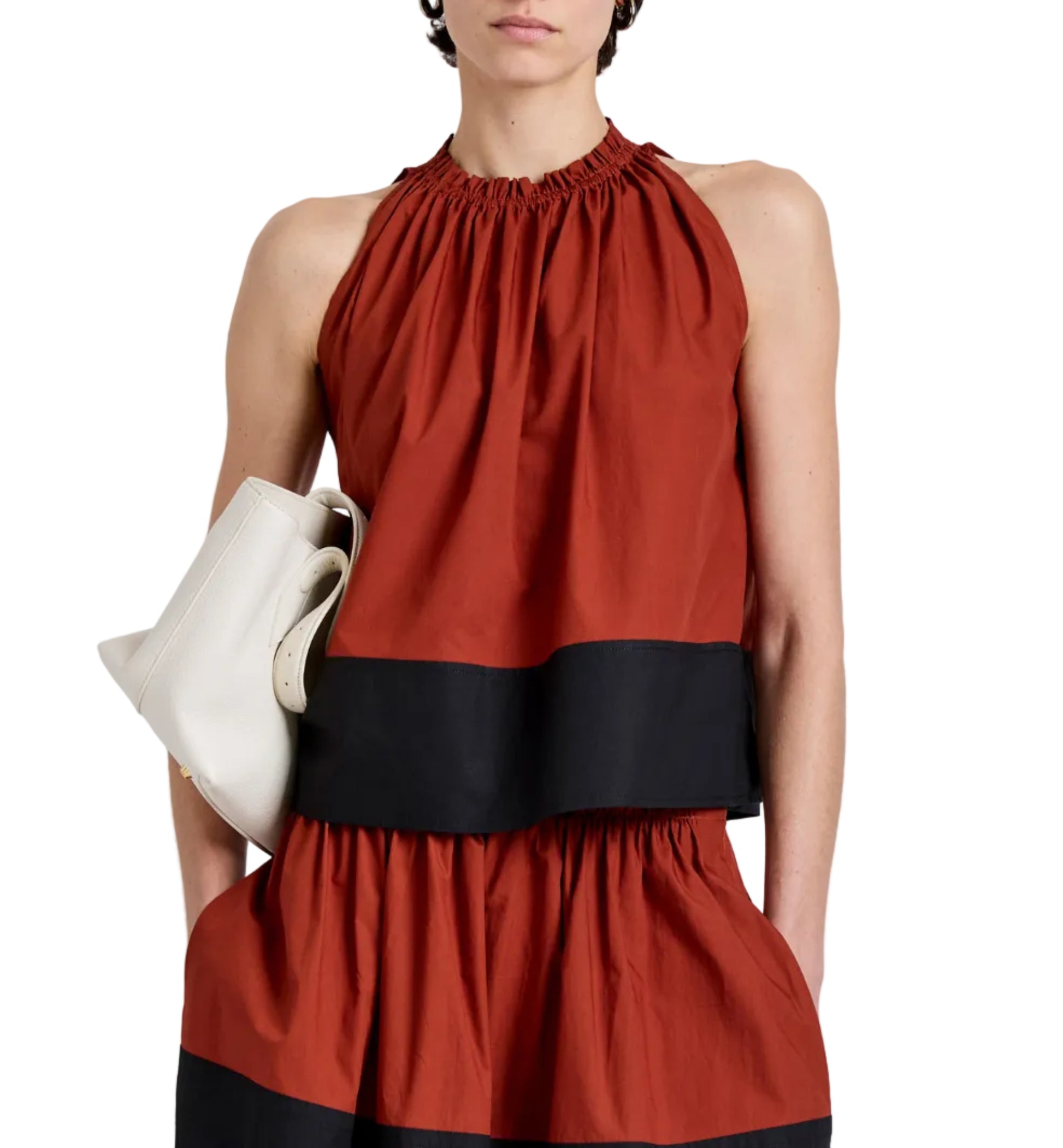 Cropped silhouette of a person wearing the Esme Top by Proenza Schouler White Label, holding a white clutch bag, shown from shoulders to knees against a plain background.