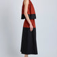 A person stands sideways against a plain background wearing the Esme Top by Proenza Schouler White Label in a cropped, sleeveless, rust and black color-blocked style, paired with black sandals.
