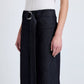 Model wears the Lina Pant by Proenza Schouler White Label—high-waisted stretch twill with an adjustable belt and silver buckle—paired with a white short-sleeve top, against a plain background.