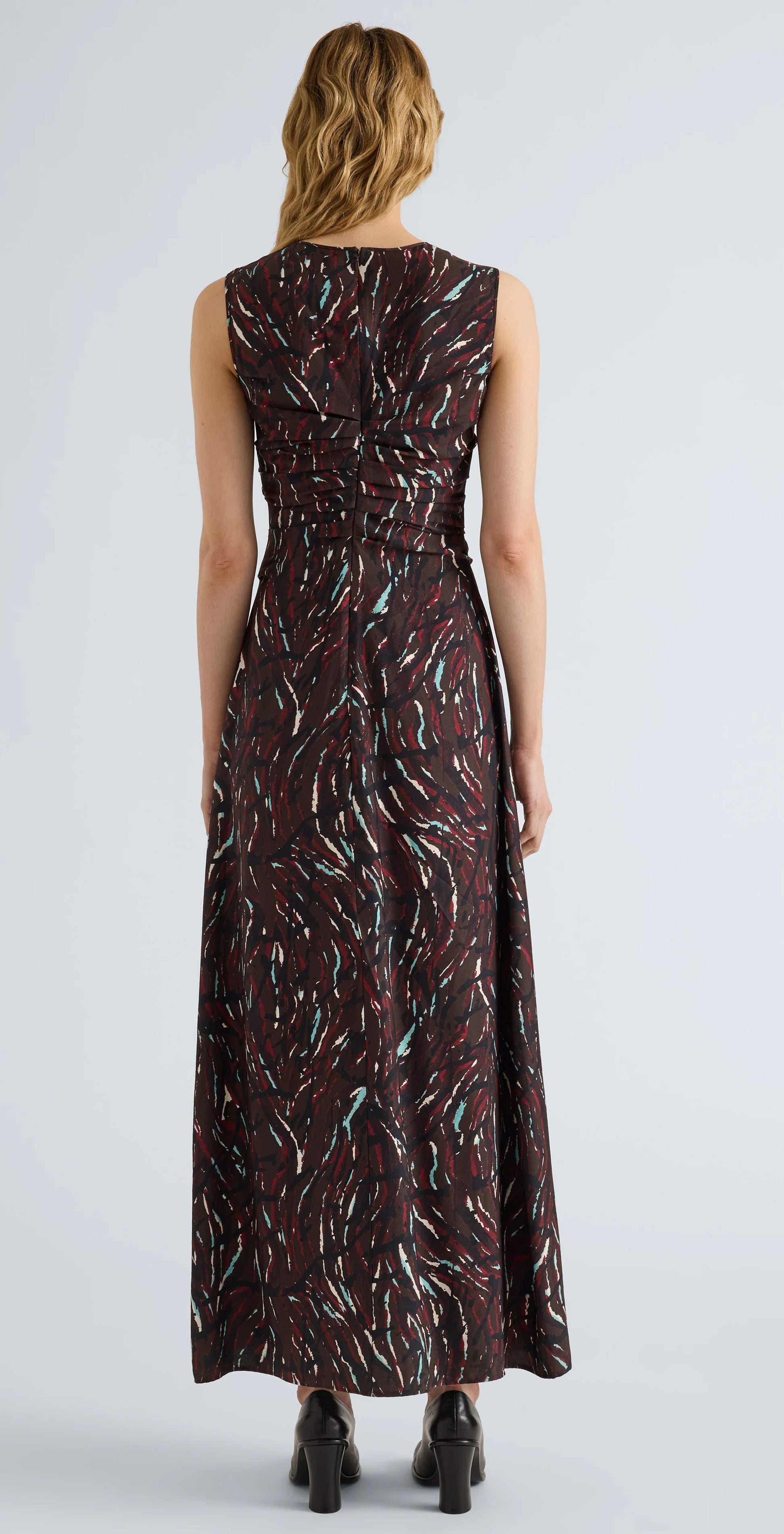 A person is shown from the back against a plain light background, wearing the Proenza Schouler White Label Clem Dress—a sleeveless, ankle-length piece crafted in printed soft twill with a dark abstract pattern.