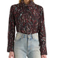 A person is wearing the Ansel Printed Soft Twill Top by Proenza Schouler White Label—a high-neck, long-sleeve blouse featuring red, white, and teal streaks—paired with light blue high-waisted jeans.