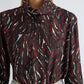 A person wearing the Proenza Schouler White Label Ansel Printed Soft Twill Top—a long-sleeve, high-neck piece featuring an abstract maroon, white, and teal pattern with a subtle cowl turtleneck—paired with light blue jeans.