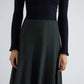 A person wears a textured long-sleeve black top paired with the Proenza Schouler White Label Heidi Stretch Cotton Skirt, a high-waisted, dark skirt; only their torso and upper legs are visible against a plain background.
