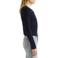 Side view of a person wearing a navy blue Proenza Schouler White Label Marci Cardigan in Ric Rac Cotton over a cream-colored turtleneck and light-wash jeans.