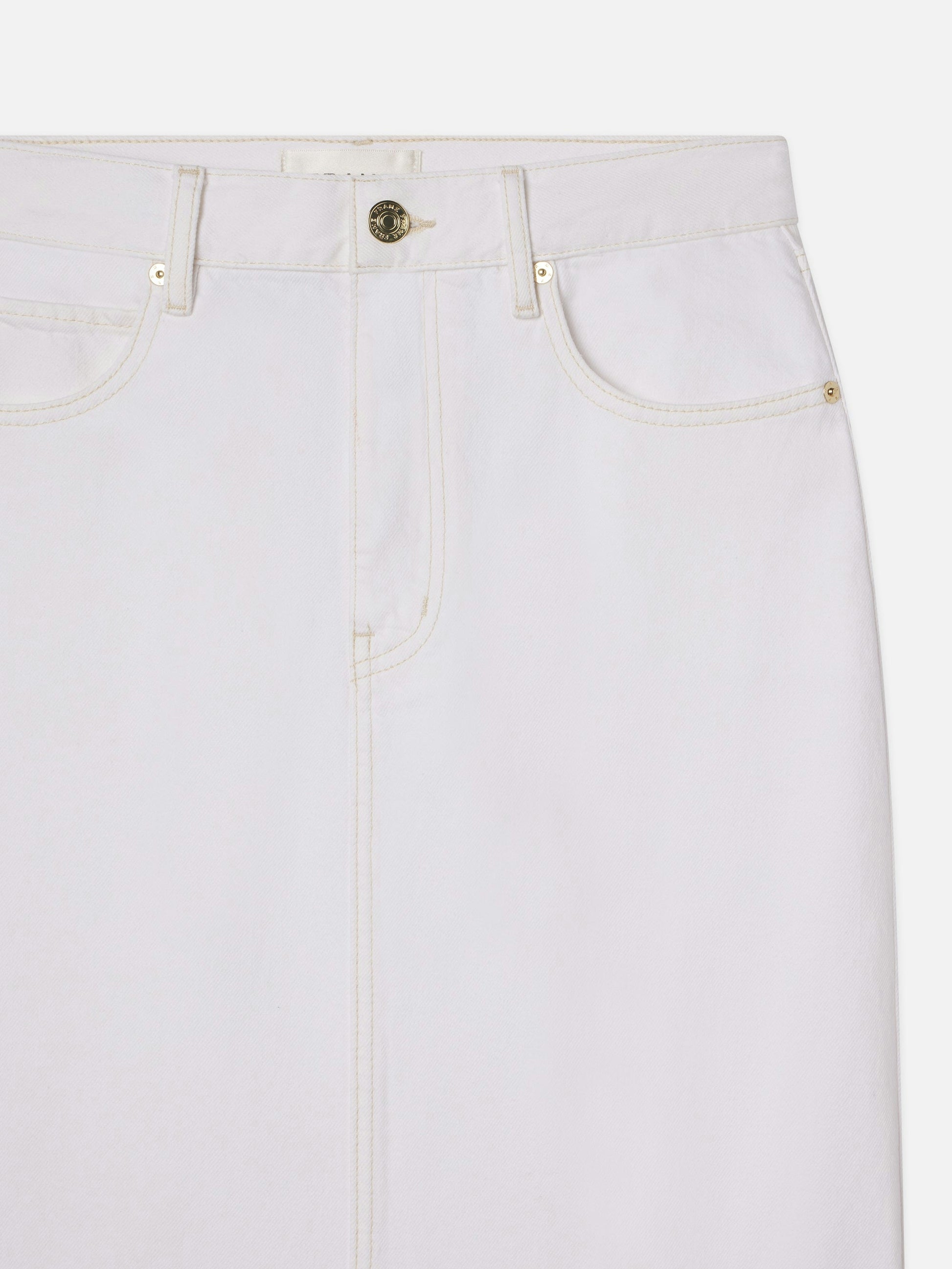 Close-up of the upper half of The Flounce Denim Skirt by Frame, a white denim maxi skirt with front pockets, belt loops, and a button closure.