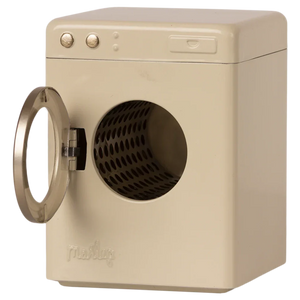 A beige, front-loading Maileg Washing Machine, Miniature with its door open reveals the empty drum inside. The metal machine, from the renowned brand Maileg, features two control knobs on the top left corner, ready to tackle your laundry needs.