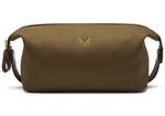 The Bennett Winch Canvas Wash Bag features a brown canvas material, a YKK brass zipper closure, leather side handles, and a subtle butterfly design on the front.