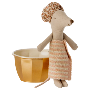 The Maileg Wellness Mouse, Big Sister - Rose, dressed in a striped towel dress and shower cap, stands next to a yellow cup with a white interior, ready for fun in her playset featuring a golden metal bathtub.