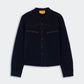Cropped Western Shirt by Guest in Residence in dark navy cashmere, featuring a collar, brown piping on the chest, long sleeves, and a straight hem, displayed against a light background.