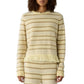 Someone wears the Western Stripe Crew by Guest in Residence—a cream and beige striped sweater with a fringed hem—paired with matching knit pants.
