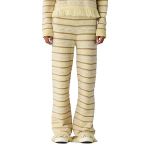 Only the lower body is visible, featuring the Western Stripe Pant by Guest in Residence styled with a matching fringe top.