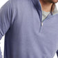 A man is wearing the Peter Millar Crown Comfort Pullover in light blue, featuring four-way stretch fabric, layered over a gray shirt.