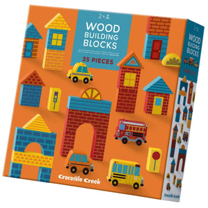 The Crocodile Creek Build & Play Wood Blocks Busy City set includes 35 city-themed wooden blocks and vehicles for ages 2+, packaged in an orange box with vibrant illustrations.