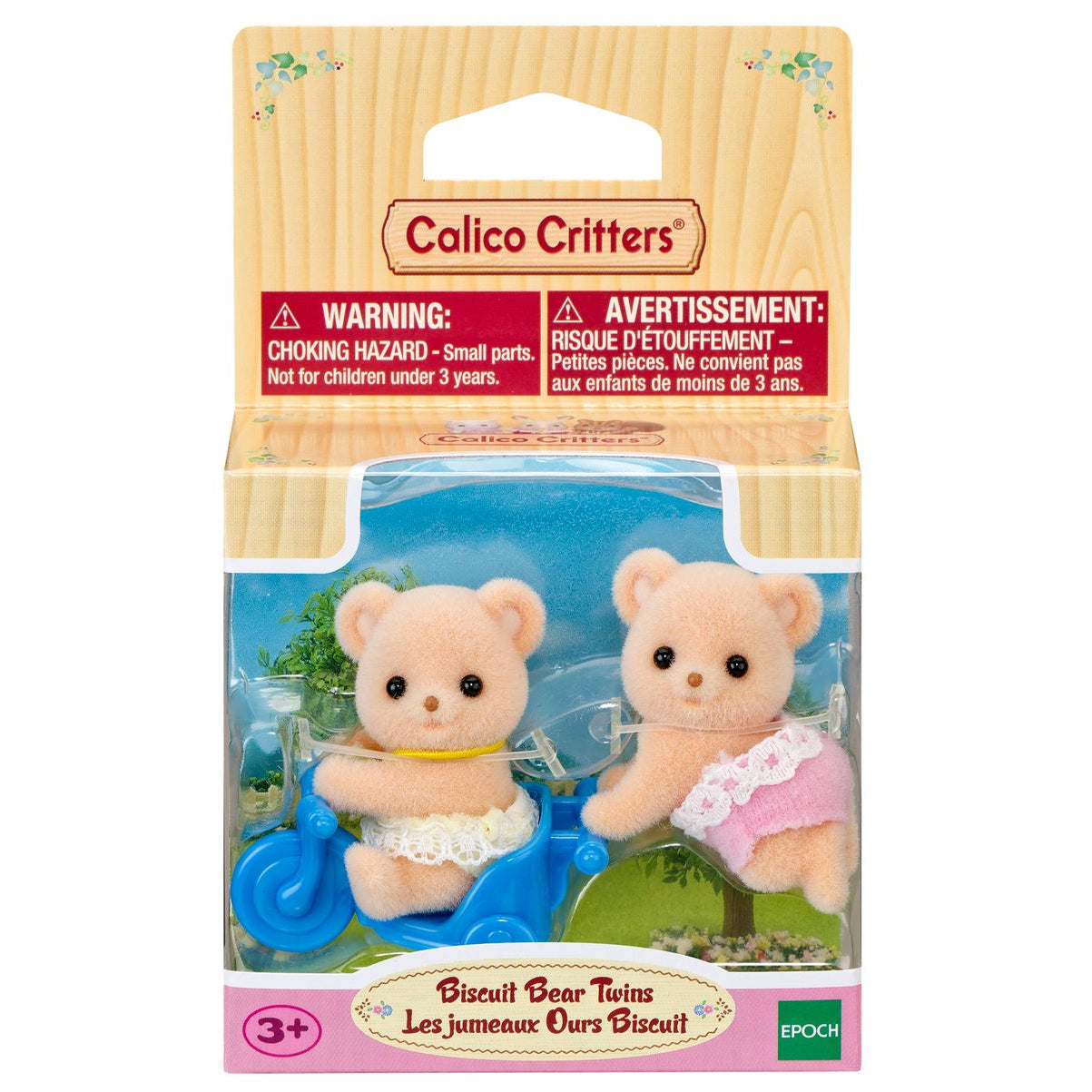 Two fuzzy Biscuit Bear twins in diapers—one riding a blue scooter, the other standing next to a tricycle—come packaged in a Calico Critters box labeled “Biscuit Bear Twins” with a choking hazard warning for ages 3 and up.