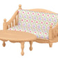 A petite light-wood sofa with a patterned cushion and a coordinating oval coffee table, ideal for a Calico Critters Chocolate Rabbit girl to unwind in her Calico Critters Red Roof Cozy Cottage.