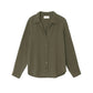 The Xirena Scout Cotton Gauze Shirt, shown on a plain white background, features an olive green hue, long sleeves, a button-up front with a collar, and a shirttail hem. It's crafted from textured washed cotton gauze fabric.