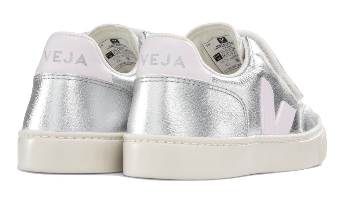 A pair of Veja Junior V-12 Velcro Sneakers in metallic silver with white soles and pink logo detail, made from organic cotton.