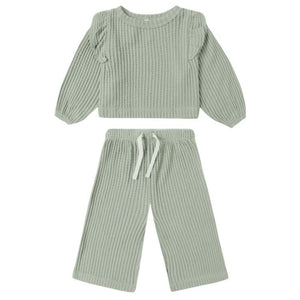 The Quincy Mae Baby Girl’s and Girls’ Ruffle Cozy Set features a light sage green fuzzy waffle knit long sleeve top with ruffles and matching wide-leg drawstring pants.