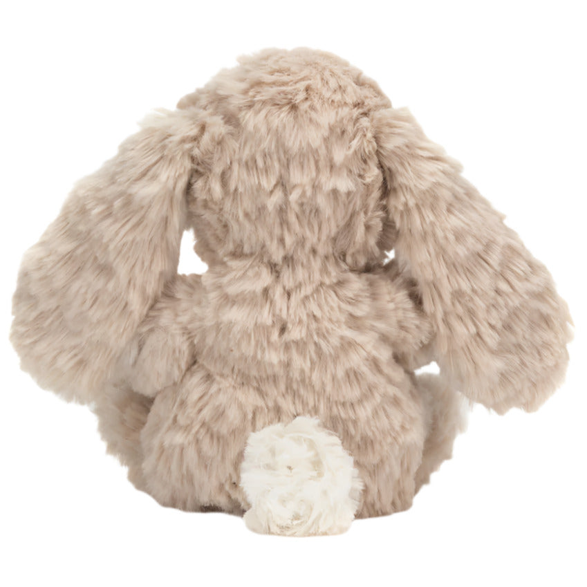 The Jellycat Yummy Bunny plush toy by Jellycat features long floppy ears and a white tail, shown from behind against a white background.