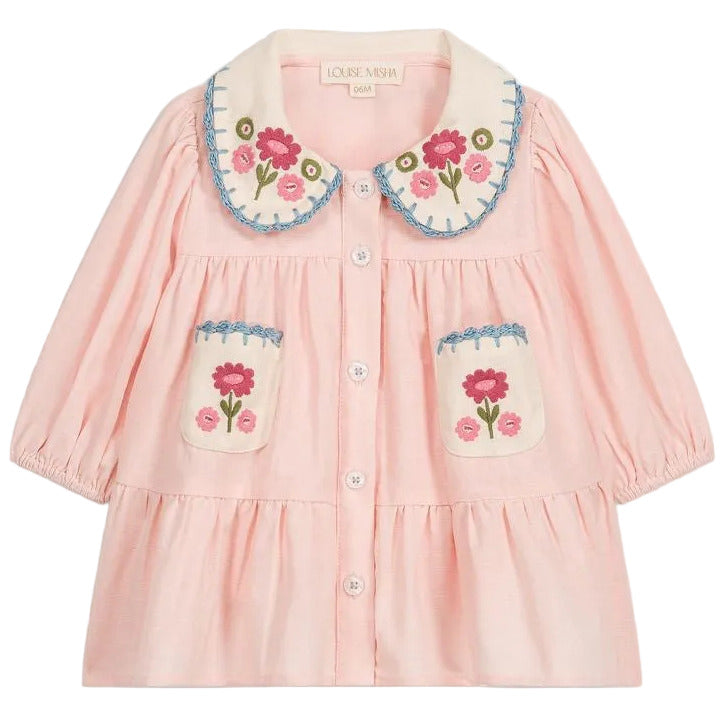 Louise Misha’s Baby Girls’ and Girls’ Ysee Dress features a delicate light pink design with long sleeves, blue trim, and elegant floral embroidery accenting the collar and two front pockets. Hand-crocheted finishes add a charming touch, while six white buttons fasten the dress down the front.