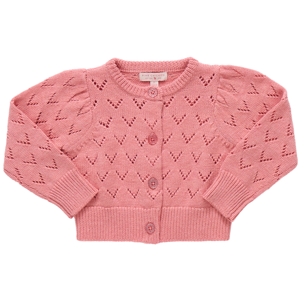 The Girls' Connie Sweater by Pink Chicken is a pink pointelle cardigan with heart-shaped eyelets, long sleeves, ribbed cuffs and hem, and glitter button closure on the front.
