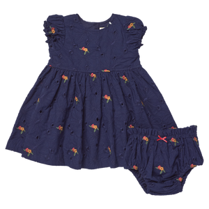 The Pink Chicken Baby Girls' Eliza Eyelet Embroidery Dress Set features navy blue fabric, short ruffled sleeves, delicate navy floral eyelet embroidery, and comes with matching bloomers—the charming set is displayed side by side on a white background.
