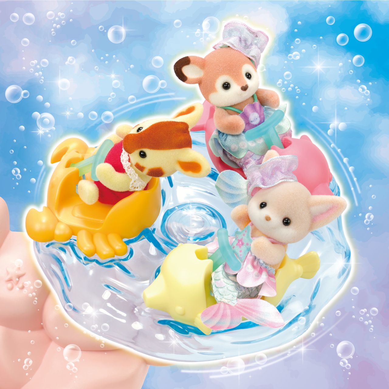 Three small baby figures from Calico Critters’ Baby Mermaid Castle wear pastel outfits as they ride animal-shaped floats through swirling water, set against a blue, bubbly backdrop that captures the enchantment of a sea-themed amusement park.