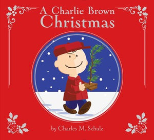 The Simon & Schuster "Charlie Brown Christmas, Deluxe Edition" storybook cover shows Charlie Brown with a small tree in the snow, framed by red borders and white holly—ideal for holiday gifting.