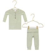 The Lou Lou & Company Baby Collins Plush Knit Top & Bottoms set, shown in light green, features a long-sleeve button-up shirt and matching pants with a fold-over waistband, both displayed on gold hangers against a white background.