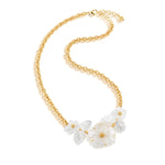 The Juliska Capucine De Wulf Mermaid Garden Bouquet Necklace is a gold link chain with clear, clustered flower and leaf-shaped pendants as its centerpiece.