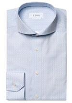 A neatly folded Eton Light Blue Geometric Print Signature Poplin Shirt, Slim Fit, made from 100% cotton, featuring white buttons and a subtle pattern, labeled "Eton" on the inside collar.