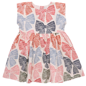 The Girls' Adaline Dress by Pink Chicken is a sleeveless kids' dress with large multicolored striped bows on a crisp white background.