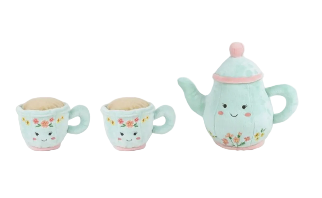 The Mon Ami Afternoon Tea Set, featuring a light blue teapot and two teacups adorned with floral patterns and cheerful, smiling faces, evokes the charm of a whimsical tea party and is displayed against a white background.
