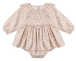 The Quincy Mae Baby Girls’ Thalia Romper features long sleeves, a ruffled collar, and a delicate pastel pink and beige floral pattern with charming embroidery, showcased against a plain white background.