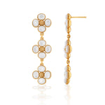 The Juliska Capucine De Wulf Berry Clover Linear Earrings feature three flower-shaped gold segments with white oval stones, resembling gemstone jewelry. Shown from front and side views on a white background.