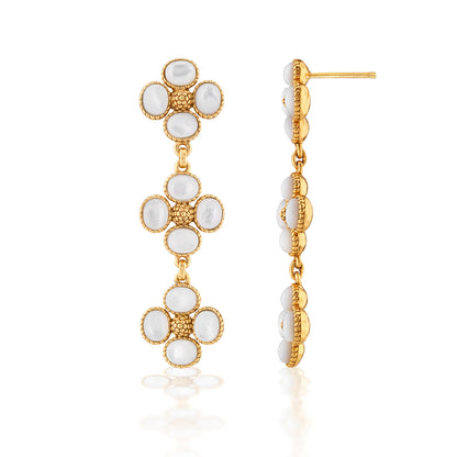 The Juliska Capucine De Wulf Berry Clover Linear Earrings feature three flower-shaped gold segments with white oval stones, resembling gemstone jewelry. Shown from front and side views on a white background.