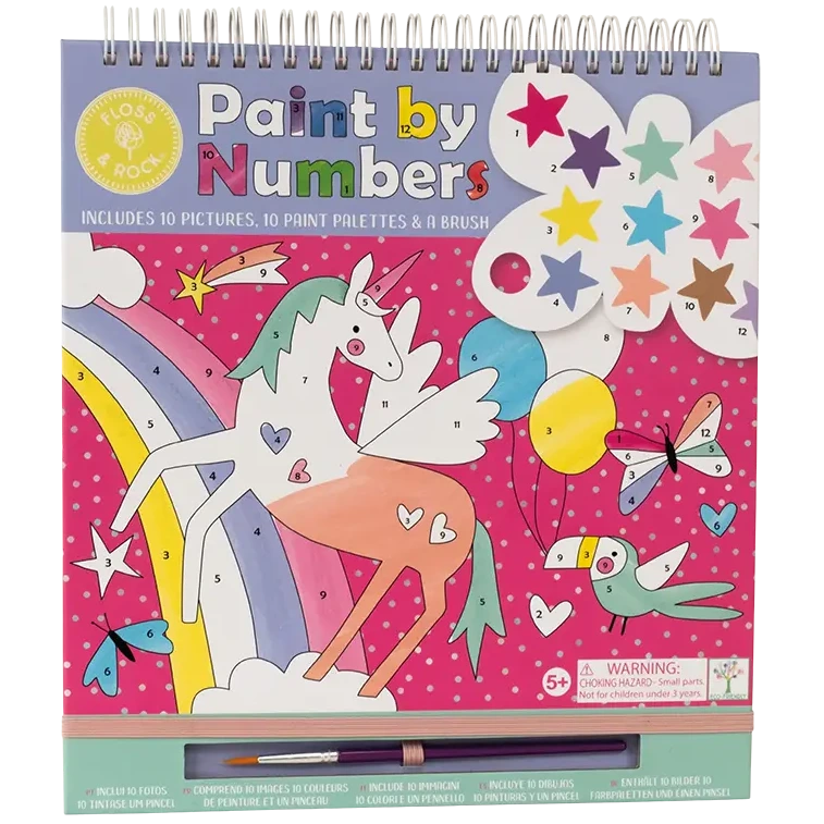The Floss and Rock Fantasy Paint By Numbers kit is a spiral-bound art set for kids ages 5 and up, featuring a vibrant pink background with polka dots, and playful designs including a colorful unicorn, rainbow, stars, bird, and paintbrush.