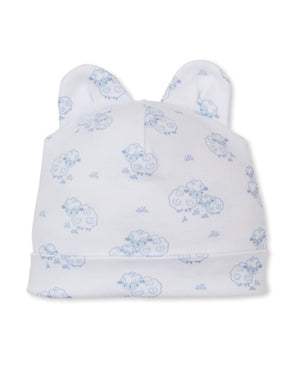 The Kissy Kissy Baby Sweet Sheep Hat is a white baby hat with two ear-shaped points, made from the softest Pima cotton and adorned with a pattern of light blue sheep illustrations—perfect for comfy, soft baby clothes.