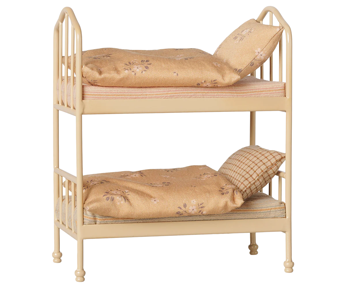 A cozy Wheat Bunk Bed - Mouse by Maileg, featuring a small beige metal frame with floral-patterned bedding and pillows on both the top and bottom bunks, set against a plain background—ideal for sleepovers at Mouse Hole Farmhouse.