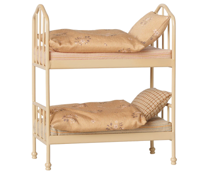 A cozy Wheat Bunk Bed - Mouse by Maileg, featuring a small beige metal frame with floral-patterned bedding and pillows on both the top and bottom bunks, set against a plain background—ideal for sleepovers at Mouse Hole Farmhouse.
